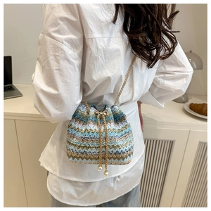 Detail of woven bucket bag featuring color-block waves and elegant pearl chain drawstring