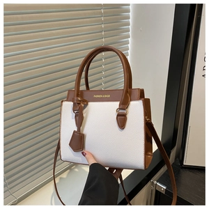 Detailed view of the lychee texture and gold foil lettering on the contrast handbag
