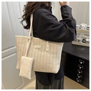 Detail of a woven straw tote bag with a matching small leather pouch on a shoulder strap