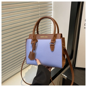 Detail of lavender litchi pattern faux leather crossbody bag with brown handles