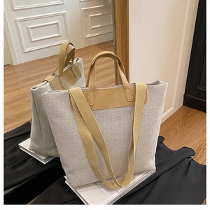 Detail of the high-density canvas tote bag with brown leather handles and wide strap