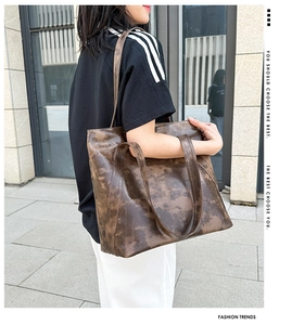 Close-up of a large vintage brown PU leather tote bag with soft texture and dual handles