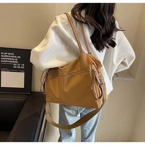 Tragebeispiel einer caramelbraunen Nylon-Tasche mit verstellbarem breitem Schultergurt