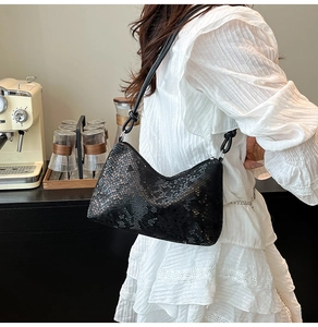 Detail of black snake pattern hobo bag with unique knotted strap on shoulder
