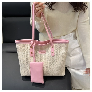 Detail of straw woven tote bag with pink leather trim and matching mini bag charm
