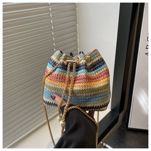 Macro detail of bohemian colorful striped woven bucket bag with pearl chain drawstring