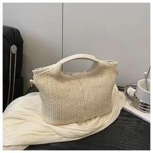 Détail du sac cabas tressé crème avec bordure en cuir et fixation par anneau en D métal