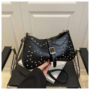 Détail du sac croissant noir gaufré croco avec rivets dorés et boucle en cuir élégante