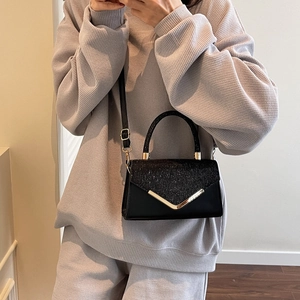 Fashionable black square crossbody bag with gold V-metal trim and glitter flap detail