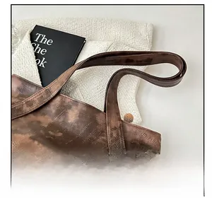 Detail shot of vintage coffee brown leather tote with soft texture and durable stitching