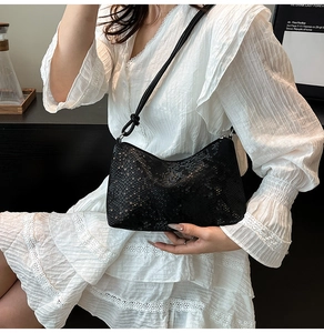Detail of black snakeskin texture and knotted strap on minimalist shoulder bag