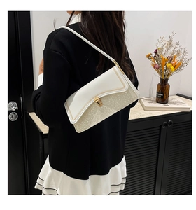 Detail of elegant two-tone shoulder bag featuring white leather and silver sequins finish