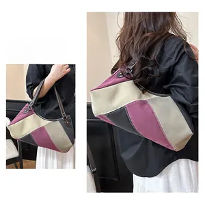 Detail der farblich abgesetzten Canvas-Tasche mit Kontrastnähten und Ledergriffen