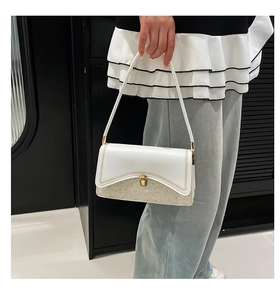 Detail of contrasting panel shoulder bag with silver glitter and gold chain trim