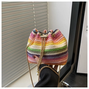 Close-up of rainbow woven bucket bag with golden chain and white pearl charms