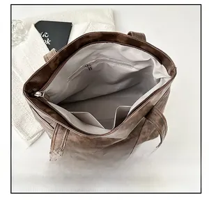 Detail view of large brown tote bag interior with zipper pocket and spacious lining