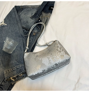 Detail showing metallic silver snakeskin texture on a chic rectangular underarm bag