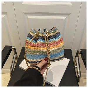 Detail of colorful woven bucket bag with gold chain strap and pearl accent decoration