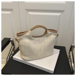Détail du sac cabas tressé beige avec poignées en cuir marron et boucle en métal latérale