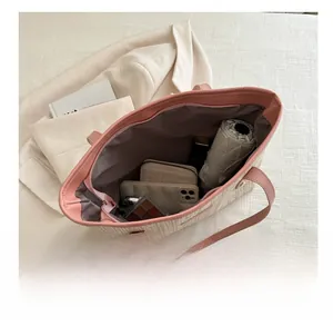 Detail showing the large interior capacity of this woven tote bag with daily essentials