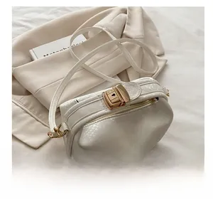 Detail of white snake-embossed leather handbag featuring a premium gold metal clasp lock