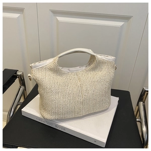 Détail d'un sac cabas tissé crème avec poignée lisse sur un fond blanc minimaliste