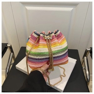 Detail of rainbow woven bucket bag featuring gold chain strap and pearl drawstring accents