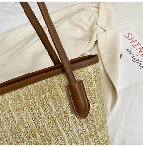 Close-up of the woven straw texture and premium brown leather trim on the tote bag