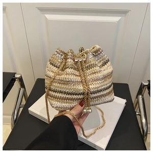 Close-up of woven bucket bag with pearl charms, gold chain strap and striped texture