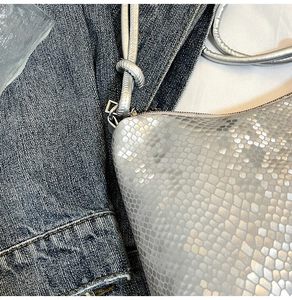 Detailed macro view of silver snake-embossed leather texture and knotted strap design