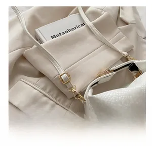 Detail of white animal embossed texture bag with adjustable golden metal buckle
