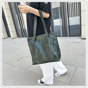 Deep green retro tote bag with marble texture texture held by a model on a street