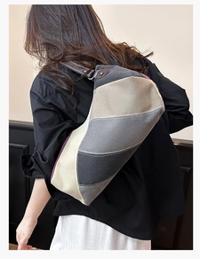 Detail der Canvas-Tragetasche mit Patchwork-Muster und braunem Lederriemen mit Ziernaht