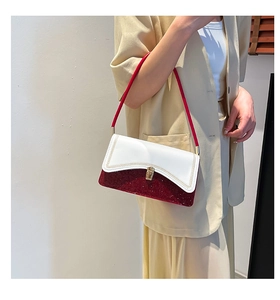 Detail of a color-block shoulder bag with white leather and red sequins on model