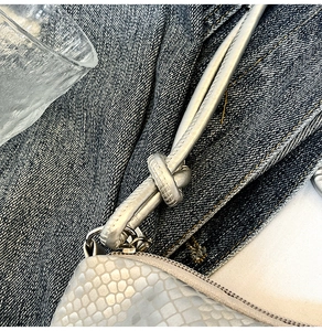 Detail of silver faux snake skin bag with knotted strap and metallic texture