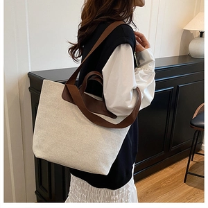 Detail of minimalist cream canvas tote bag with brown faux leather shoulder straps