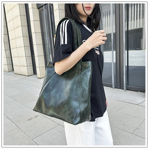 Detail view of the large dark green tote bag with retro oil wax leather texture in use