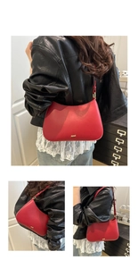 Close-up of red crescent underarm bag with gold logo and adjustable leather strap