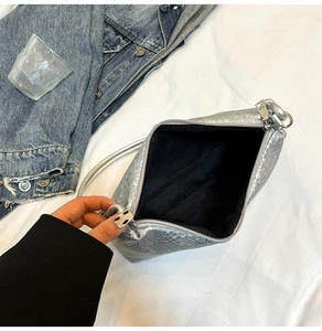 Detail of silver snake-pattern bag interior with metal zipper and black lining