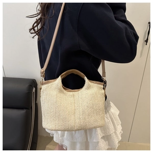 Détail du sac cabas en paille tressée avec bordure en cuir marron et boucle métallique