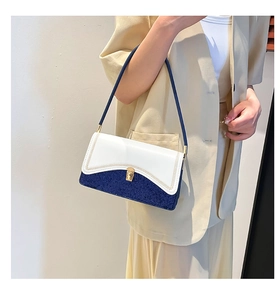 Detail of color-block flap bag featuring white leather and blue tweed with a metal buckle