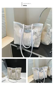 Détail d'un sac cabas en paille blanche avec nœud en dentelle et anses en cuir