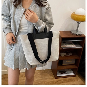 Minimalist beige and black canvas tote bag shown styled in a modern interior setting