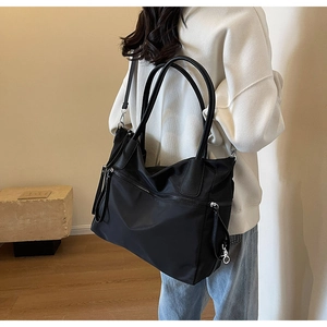 Detaillierte Seitenansicht einer schwarzen Nylon-Tasche an einem Modell mit viel Stauraum