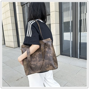 Brown leather tote bag showing large capacity size and retro texture on model