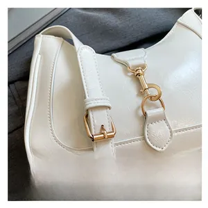 Close-up of cream faux leather hobo bag with adjustable strap and gold metal lobster clasp