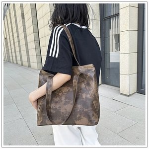 Detailed view of large brown tie-dye tote bag with soft vintage leather texture