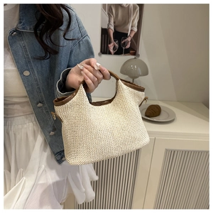 Détail du sac seau tissé beige avec bordure en cuir marron et boucle en métal en forme de D