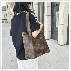 Detail of large tote bag with vintage dark brown marble texture shown on shoulder