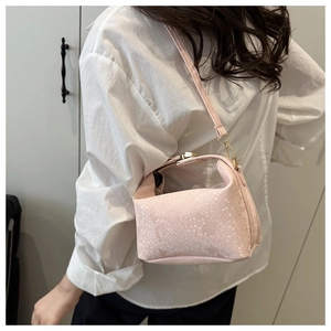 Detail of light pink mini bag with snakeskin texture and golden metal buckle details